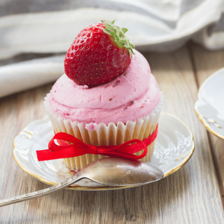crema de mantequilla sobre cupcake de fresa