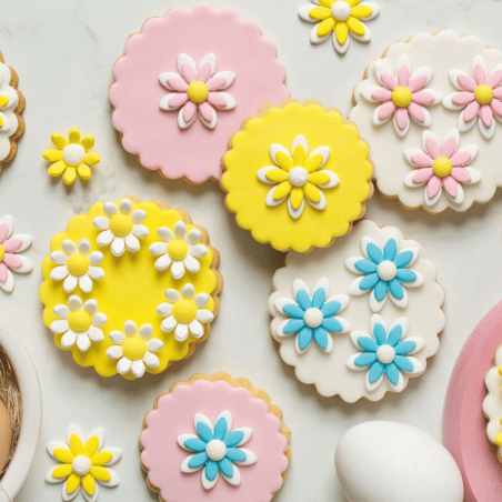 Galletas decoradas con margaritas de azúcar de color azul claro.