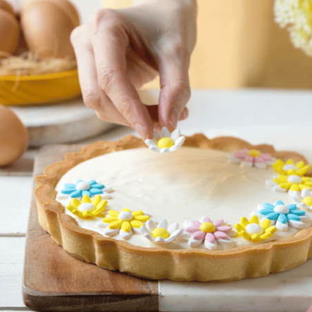 Tarta de primavera decorada con flores comestibles de azúcar de color azul claro.
