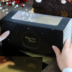 Caja de madera negra con motivos dorados, felices fiestas