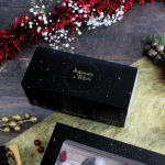 Caja negra para tronco de Navidad con inscripción dorada "Felices Fiestas".